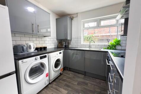 Modern fitted kitchen with sleek grey cabinets,...