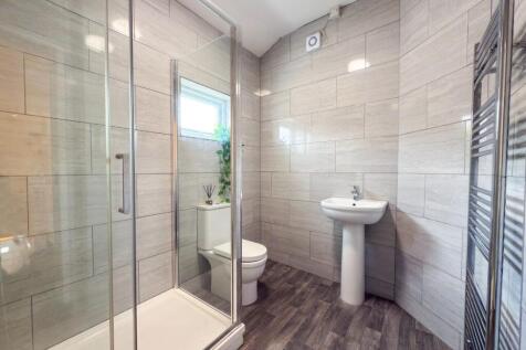 Modern tiled bathroom with a walk-in glass show...