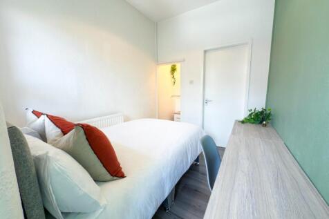 Bright, neatly styled bedroom with a comfortabl...