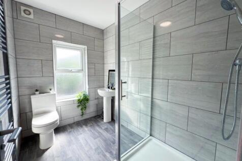 Bright, modern bathroom featuring a walk-in sho...