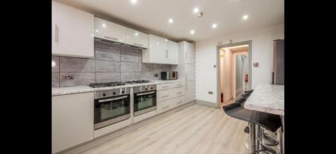 Bright modern galley kitchen with integrated ap...