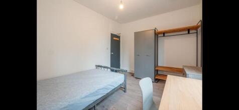 Neat furnished bedroom with a single bed, desk ...