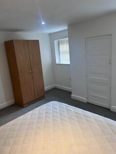 A spacious and tidy double bedroom featuring na...