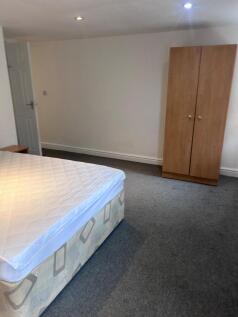 A spacious and tidy double bedroom featuring a ...