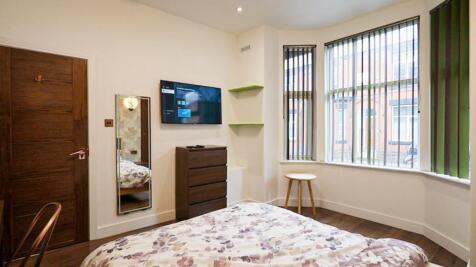 A bright and inviting double bedroom with styli...