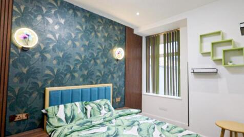 A stylish double bedroom featuring vibrant deco...