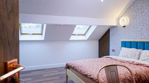 A spacious and inviting double bedroom featurin...