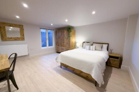 Bright, modern master bedroom with a comfortabl...