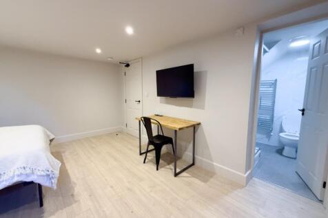 Bright, modern double bedroom with light wood f...