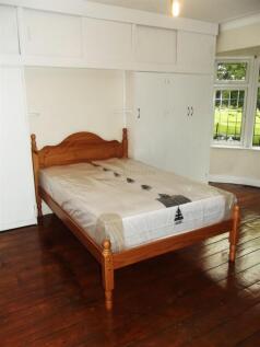 Bright bedroom with wooden flooring, fitted war...