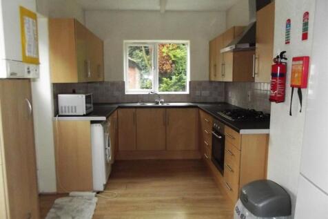 Neat fitted kitchen with light wood cabinets, i...