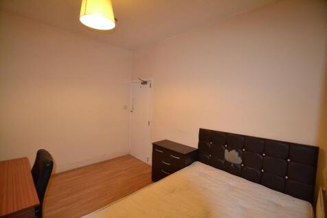 A bedroom featuring a black upholstered headboa...
