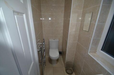 Clean and modern small bathroom with beige tile...