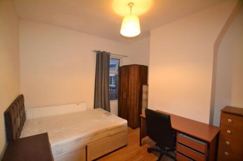 A cozy bedroom featuring a single bed, a wooden...