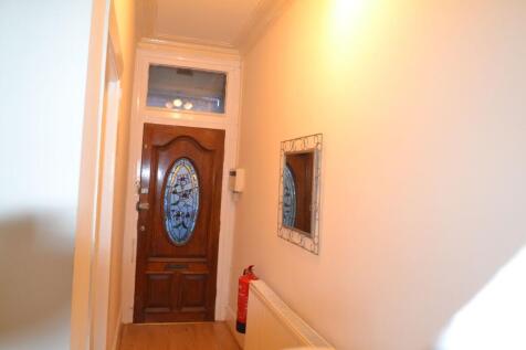 A bright and welcoming hallway featuring a wood...