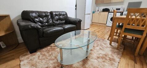 A cozy living room featuring a black leather so...