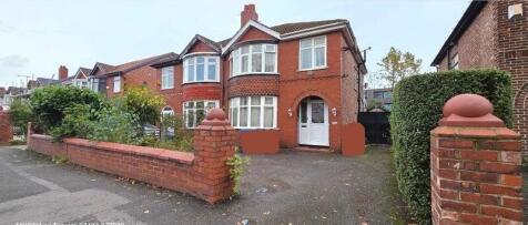 Red-brick semi-detached house with bay windows,...