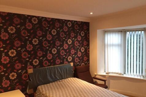 Cosy double bedroom with patterned feature wall...