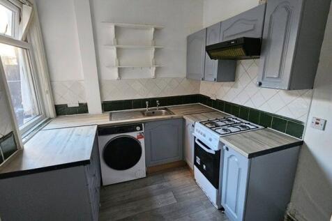A well-lit kitchen featuring blue cabinetry, a ...