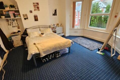 A bright double bedroom featuring a large bay w...