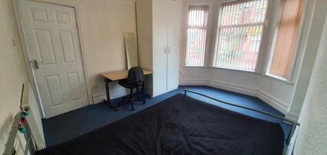 A bright double bedroom featuring a bay window ...