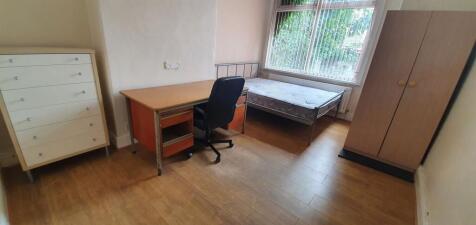 A simple and neat single bedroom featuring a st...