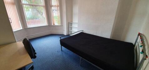 A bright single bedroom featuring a large bay w...