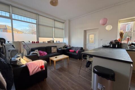Bright, modern communal lounge with large windo...