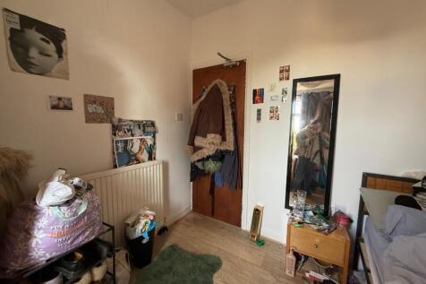 Cozy furnished bedroom with light wood floors, ...