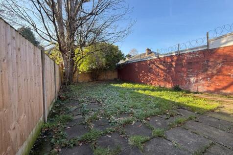 Sunny rear garden with paved patio area, mature...