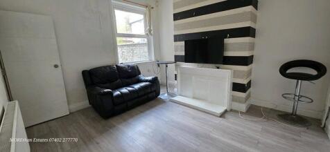 Cozy living room featuring a sleek black leathe...