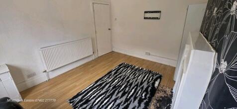 A neat and simple bedroom featuring wooden floo...