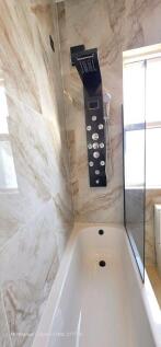 Modern bathroom featuring a sleek shower panel ...