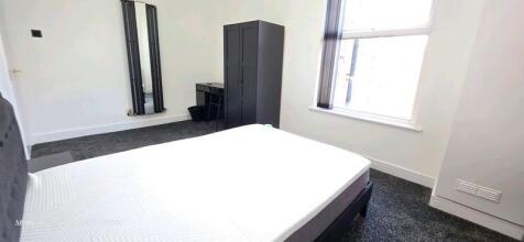 Bright and clean bedroom featuring a comfortabl...