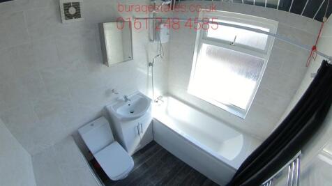 A spacious, modern bathroom featuring a large b...