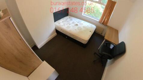 A compact bathroom featuring a toilet with mini...