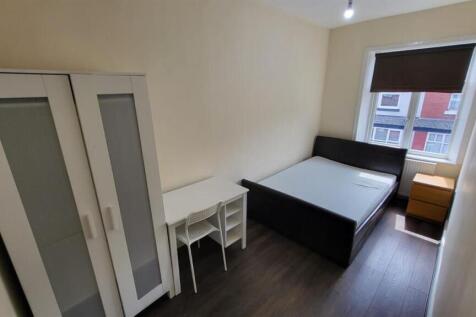 A bright and clean bedroom featuring a comforta...