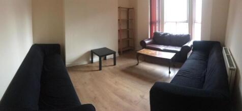 Spacious, neutral living room with two dark sof...