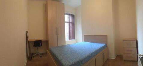 Bright, simply furnished bedroom with a double ...