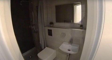 Compact modern bathroom with a walk-in shower, ...