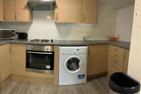 Neat modern kitchen with integrated oven, hob a...