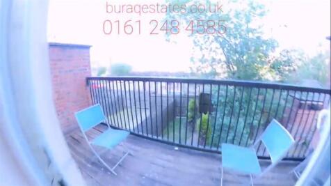 Sunny small balcony with a wooden deck, metal r...