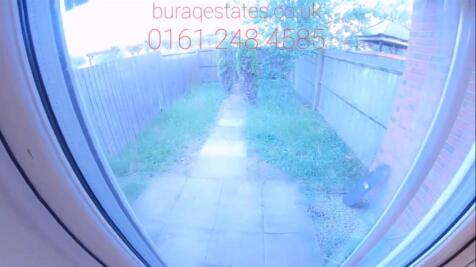 Rear garden with paved path leading from the ba...