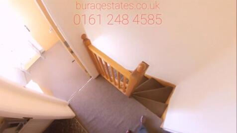 Bright, carpeted stairwell with a wooden banist...