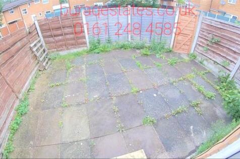 Private paved rear courtyard with surrounding t...