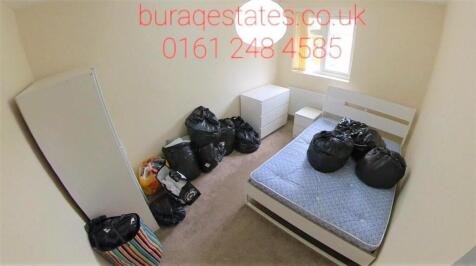 Compact bedroom with a single bed frame and mat...