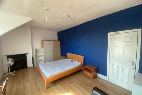 Bright, modern double bedroom with a bold featu...