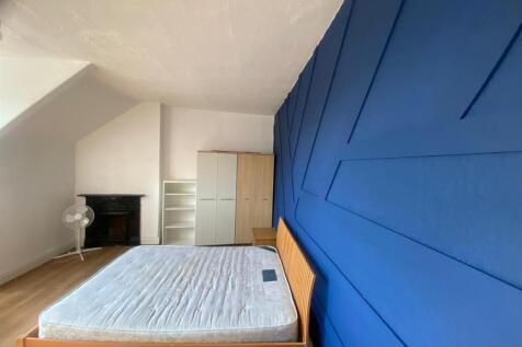 Bright, modern bedroom with a feature blue pane...