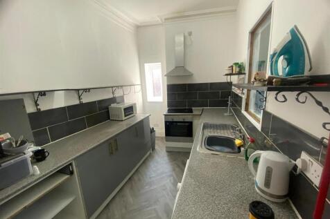 Bright galley-style kitchen with modern fitted ...