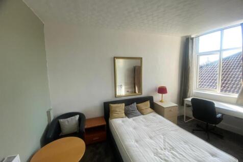 Bright single bedroom with a large window, fitt...